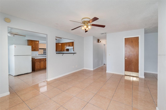 450 S Buena Vista Ave, Orlando, FL 32835 - unfurnished living room featuring a ceiling fan, light tile patterned floors, a textured ceiling, and baseboards