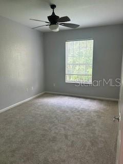8775 Sartori St Unit 307, Orlando, FL 32829 - carpeted empty room with baseboards and a ceiling fan
