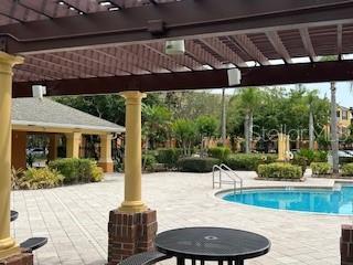 8775 Sartori St Unit 307, Orlando, FL 32829 - community pool with a pergola and a patio