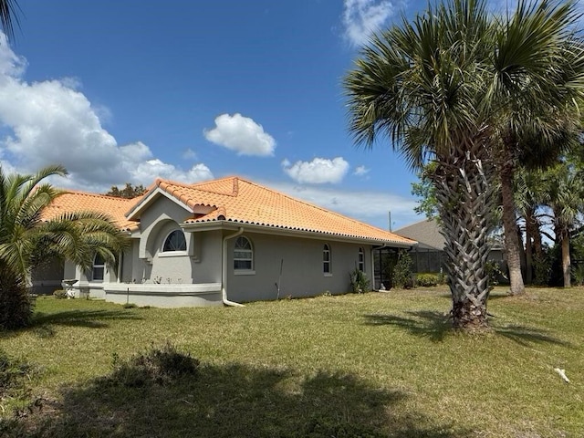 2 Bickshire Ln, Palm Coast, FL 32137 - rear view of house with stucco siding, a tiled roof, and a yard