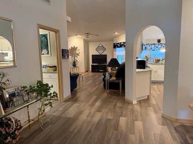 2 Bickshire Ln, Palm Coast, FL 32137 - hallway featuring light wood-style floors, arched walkways, and baseboards