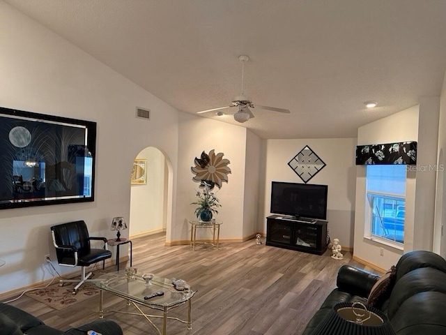 2 Bickshire Ln, Palm Coast, FL 32137 - living room with arched walkways, wood finished floors, lofted ceiling, baseboards, and a ceiling fan