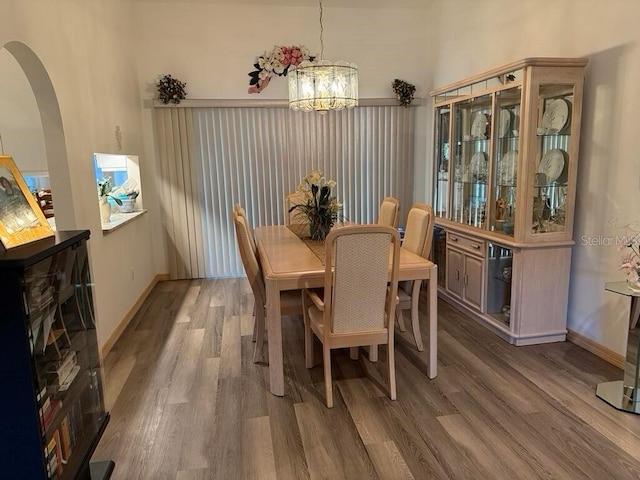 2 Bickshire Ln, Palm Coast, FL 32137 - dining space featuring a chandelier, arched walkways, wood finished floors, and baseboards