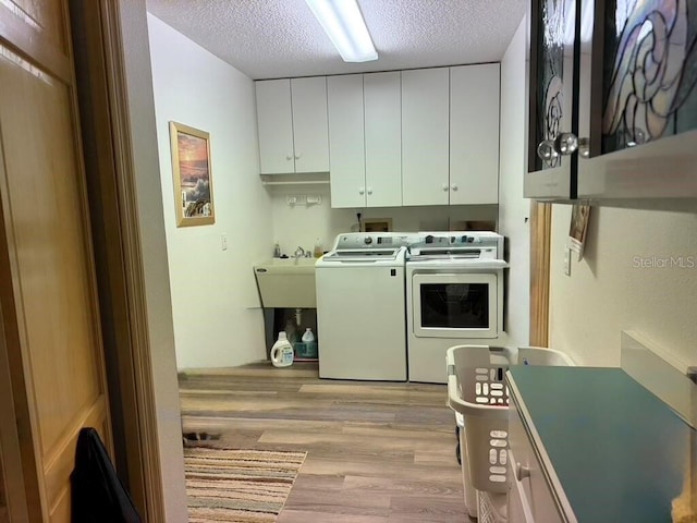 2 Bickshire Ln, Palm Coast, FL 32137 - laundry area featuring cabinet space, washer and clothes dryer, light wood-type flooring, and a textured ceiling
