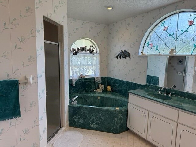 2 Bickshire Ln, Palm Coast, FL 32137 - full bath with wallpapered walls, a garden tub, vanity, a shower stall, and a textured ceiling