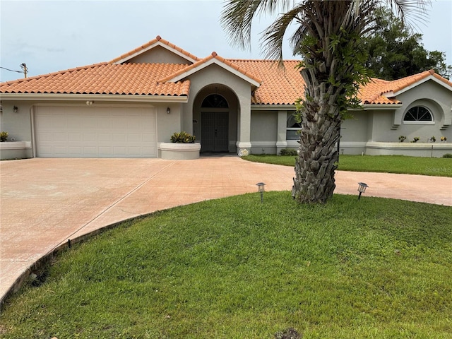 2 Bickshire Ln, Palm Coast, FL 32137 - mediterranean / spanish-style house with driveway, a front lawn, an attached garage, stucco siding, and a tile roof