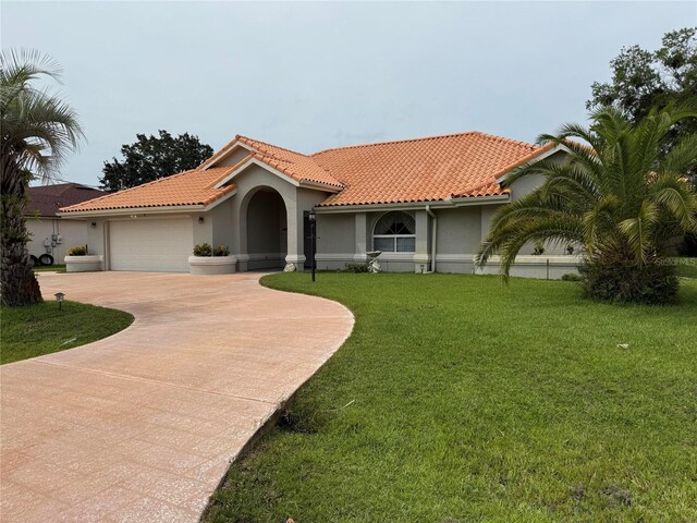 2 Bickshire Ln, Palm Coast, FL 32137 - mediterranean / spanish house with an attached garage, stucco siding, concrete driveway, a tile roof, and a front lawn