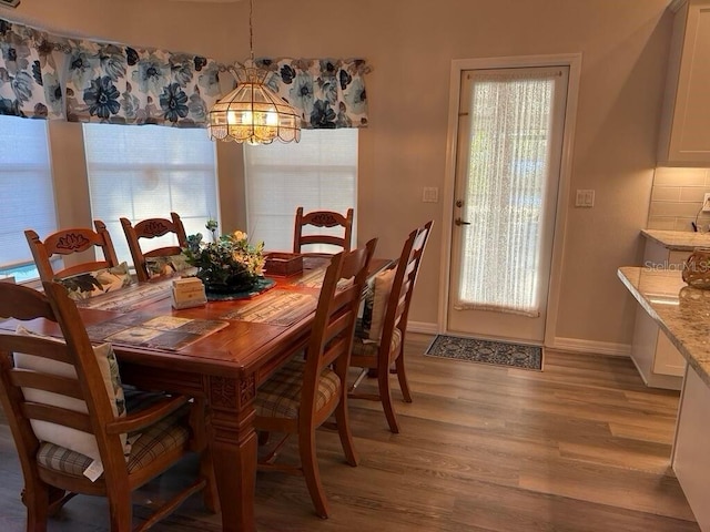 2 Bickshire Ln, Palm Coast, FL 32137 - dining space featuring light wood-style floors, a chandelier, baseboards, and healthy amount of natural light