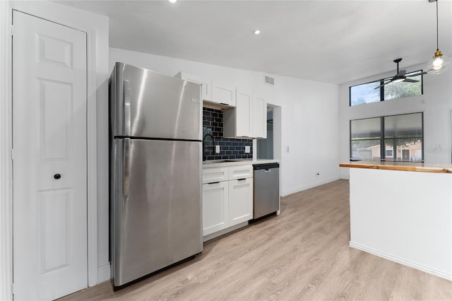 415 S Lancelot Ave, Orlando, FL 32835 - kitchen with stainless steel appliances, white cabinetry, a sink, backsplash, and baseboards