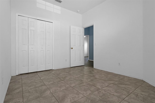 468 Jaybee Ave, Davenport, FL 33897 - unfurnished bedroom featuring a closet, a towering ceiling, and baseboards