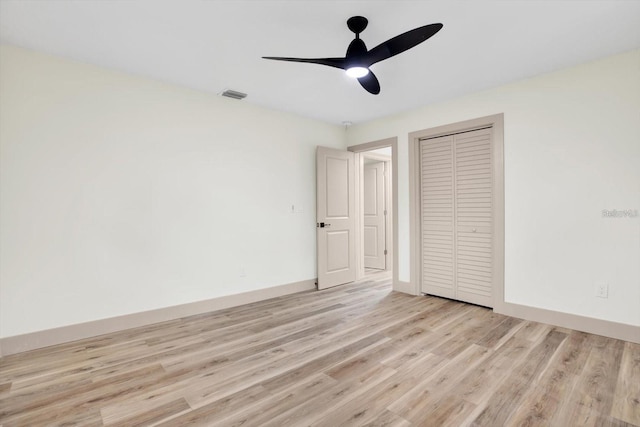 203 Driftwood Dr W, Palm Harbor, FL 34683 - unfurnished bedroom with light wood-style floors, a closet, baseboards, and a ceiling fan