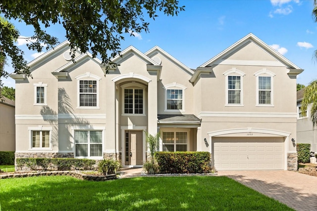 3868 Whitewood Ct, Oviedo, FL 32766 - view of front facade with stone siding, stucco siding, decorative driveway, and a front yard