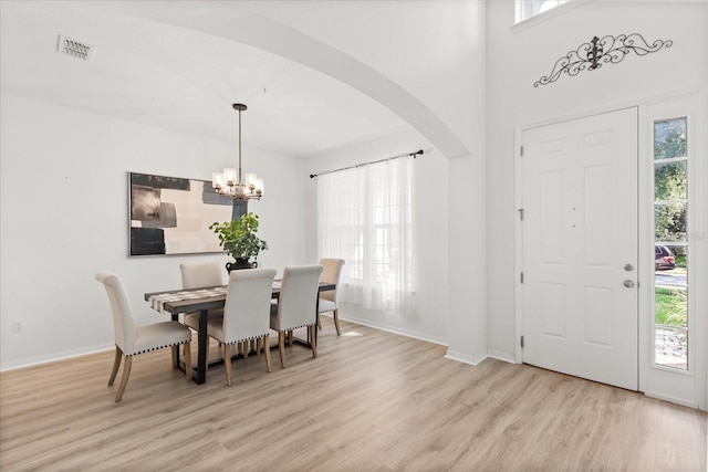 3868 Whitewood Ct, Oviedo, FL 32766 - dining space with light wood-style flooring, arched walkways, a chandelier, and baseboards