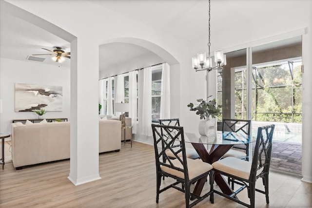 3868 Whitewood Ct, Oviedo, FL 32766 - dining room with arched walkways, ceiling fan, light wood-style flooring, and a chandelier