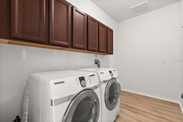 3868 Whitewood Ct, Oviedo, FL 32766 - laundry area featuring cabinet space, independent washer and dryer, light wood-style floors, and baseboards