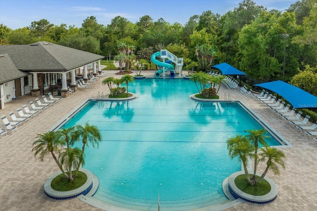 3868 Whitewood Ct, Oviedo, FL 32766 - community pool with a water slide, a patio, and view of wooded area