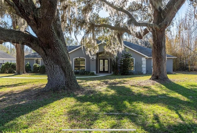 6917 Roman Ct, Clermont, FL 34714 - view of property hidden behind natural elements featuring french doors, stucco siding, and a front yard