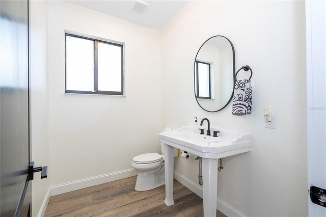 6917 Roman Ct, Clermont, FL 34714 - bathroom featuring baseboards, wood finished floors, and toilet