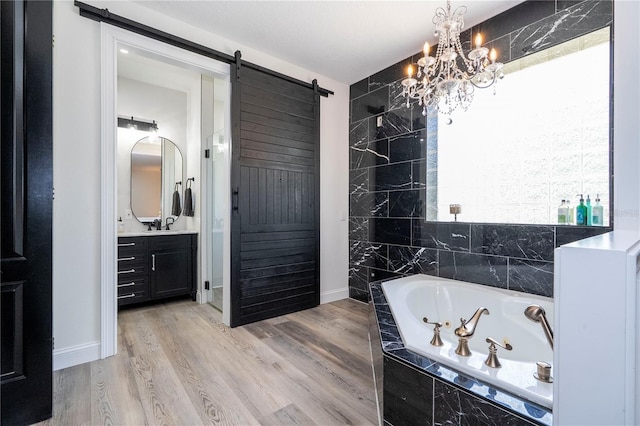 6917 Roman Ct, Clermont, FL 34714 - bathroom featuring a whirlpool tub, vanity, wood finished floors, a chandelier, and baseboards