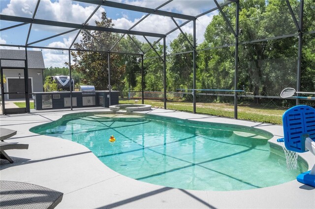 6917 Roman Ct, Clermont, FL 34714 - view of swimming pool featuring a patio area, exterior kitchen, a pool with connected hot tub, and glass enclosure
