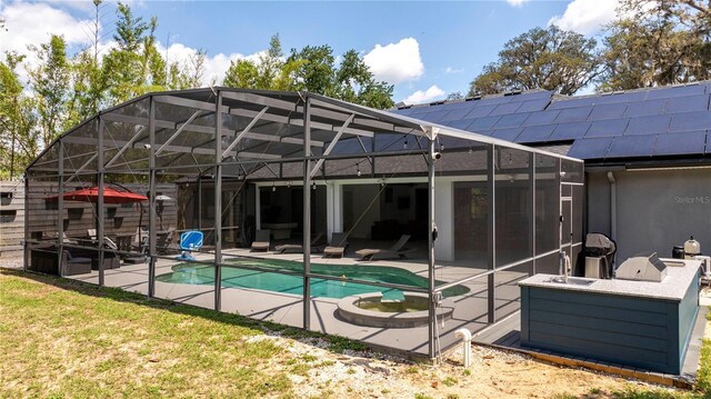 6917 Roman Ct, Clermont, FL 34714 - rear view of house featuring a patio area, roof mounted solar panels, an outdoor pool, stucco siding, and glass enclosure