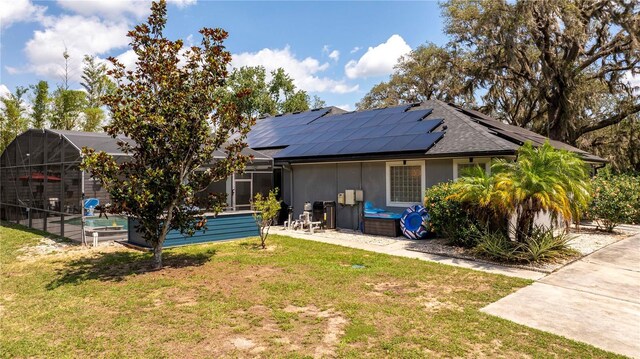 6917 Roman Ct, Clermont, FL 34714 - rear view of house with solar panels, a yard, and a swimming pool