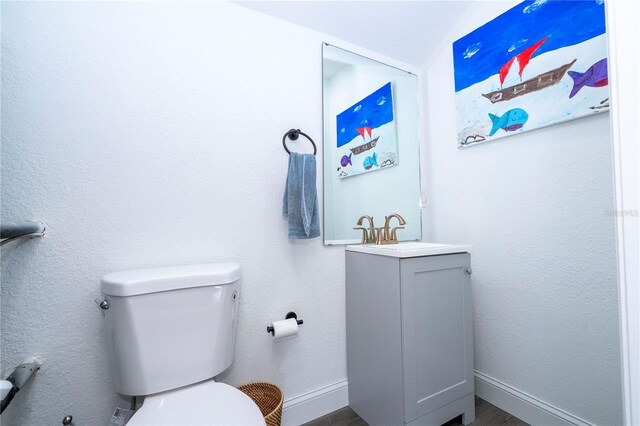 6917 Roman Ct, Clermont, FL 34714 - bathroom featuring toilet, vaulted ceiling, vanity, and baseboards