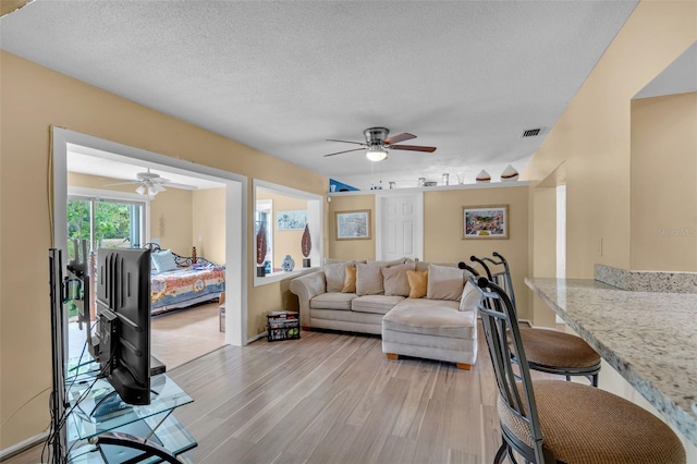 7500 NW 66th Ter, Tamarac, FL 33321 - living room with ceiling fan, light wood-type flooring, and a textured ceiling