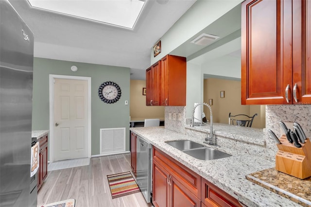 7500 NW 66th Ter, Tamarac, FL 33321 - kitchen featuring appliances with stainless steel finishes, a sink, tasteful backsplash, light wood-style floors, and light stone counters