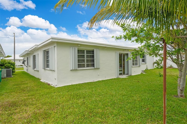 7500 NW 66th Ter, Tamarac, FL 33321 - rear view of house with stucco siding, a yard, and central air condition unit