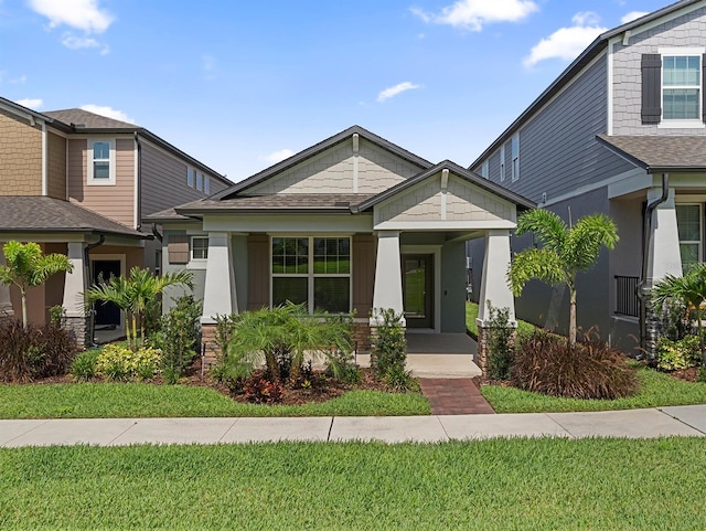 12009 Walmsley Aly, Winter Garden, FL 34787 - view of front of home featuring covered porch, a front yard, and a shingled roof