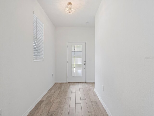 12009 Walmsley Aly, Winter Garden, FL 34787 - doorway featuring light wood-style flooring, a chandelier, and baseboards