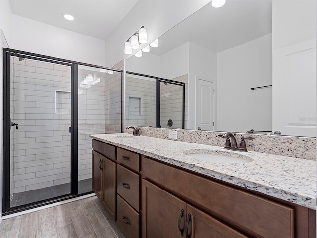 12009 Walmsley Aly, Winter Garden, FL 34787 - bathroom with double vanity, a stall shower, and wood finished floors