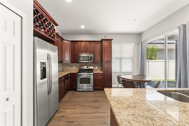 5032 Beach River Rd, Windermere, FL 34786 - kitchen featuring appliances with stainless steel finishes, dark wood-style flooring, tasteful backsplash, light stone counters, and recessed lighting