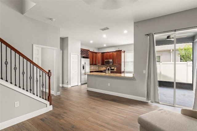 5032 Beach River Rd, Windermere, FL 34786 - kitchen featuring refrigerator with ice dispenser, stainless steel microwave, tasteful backsplash, dark wood-style flooring, and baseboards