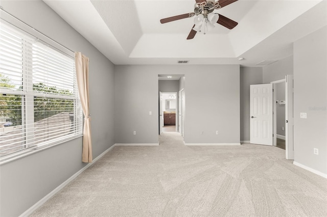 5032 Beach River Rd, Windermere, FL 34786 - unfurnished bedroom with a tray ceiling, light carpet, connected bathroom, and baseboards
