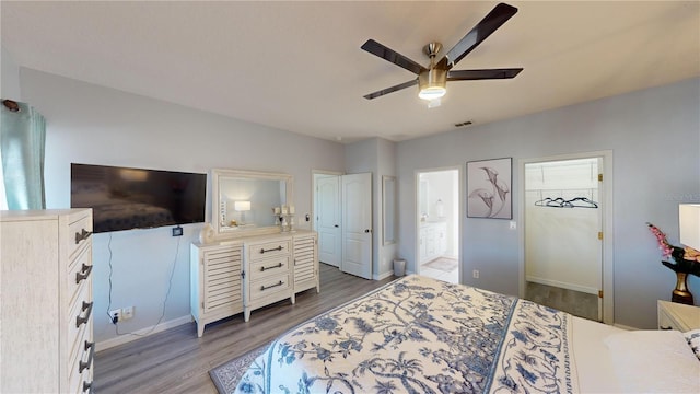 3044 Camino Real Dr S, Kissimmee, FL 34744 - bedroom featuring wood finished floors, connected bathroom, a ceiling fan, and a walk in closet