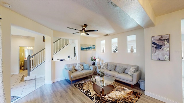 3044 Camino Real Dr S, Kissimmee, FL 34744 - living area with stairway, light wood-type flooring, a ceiling fan, and a textured ceiling
