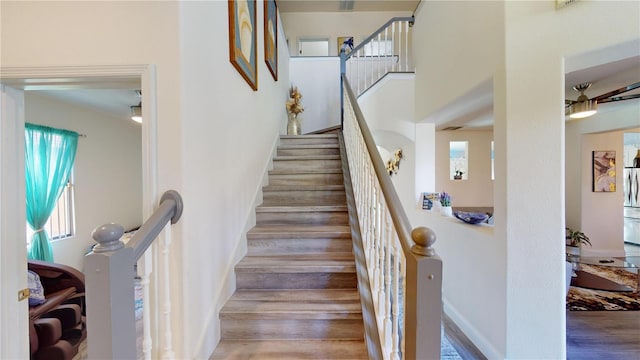 3044 Camino Real Dr S, Kissimmee, FL 34744 - staircase featuring healthy amount of natural light, wood finished floors, and a towering ceiling