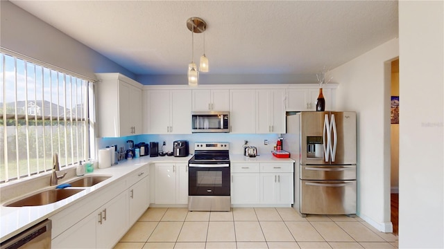 3044 Camino Real Dr S, Kissimmee, FL 34744 - kitchen featuring appliances with stainless steel finishes, plenty of natural light, pendant lighting, and white cabinetry