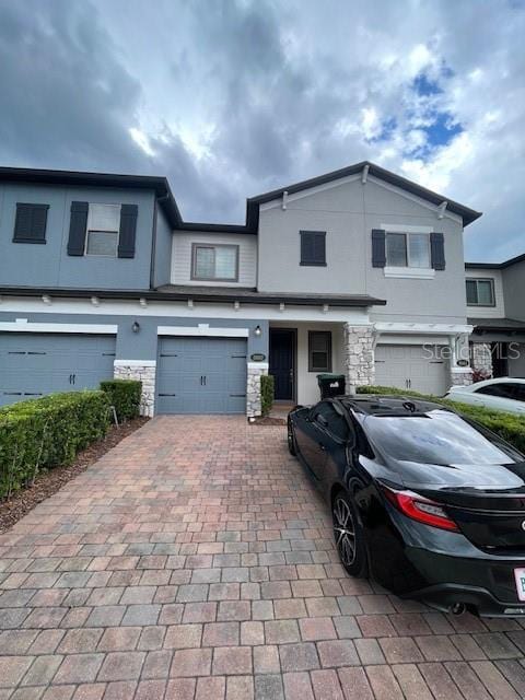 2937 Econ Landing Blvd, Orlando, FL 32825 - view of property with decorative driveway, a garage, stucco siding, and stone siding