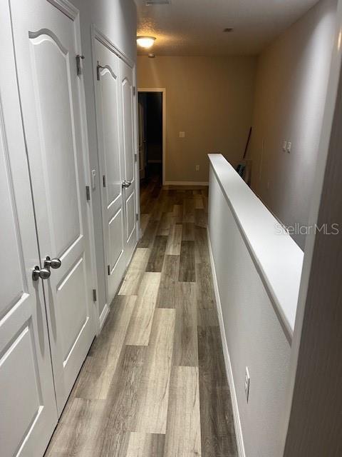 2937 Econ Landing Blvd, Orlando, FL 32825 - hallway with light wood-style floors, an upstairs landing, and baseboards