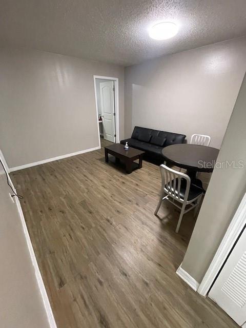 2236 Stonington Ave Unit 2236, Orlando, FL 32817 - living room featuring wood finished floors, a textured ceiling, and baseboards