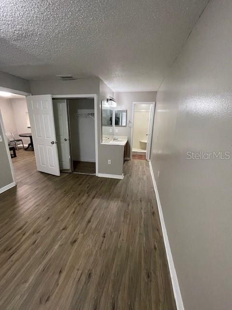 2236 Stonington Ave Unit 2236, Orlando, FL 32817 - hallway with baseboards, dark wood-type flooring, and a textured ceiling
