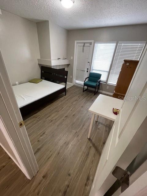 2236 Stonington Ave Unit 2236, Orlando, FL 32817 - bedroom with a textured ceiling, wood finished floors, and baseboards