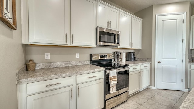 600 Buchannan Dr, Davenport, FL 33837 - kitchen with appliances with stainless steel finishes, light countertops, white cabinets, and light tile patterned floors