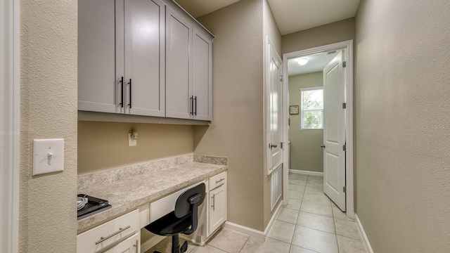600 Buchannan Dr, Davenport, FL 33837 - home office featuring built in study area, light tile patterned floors, a textured wall, and baseboards