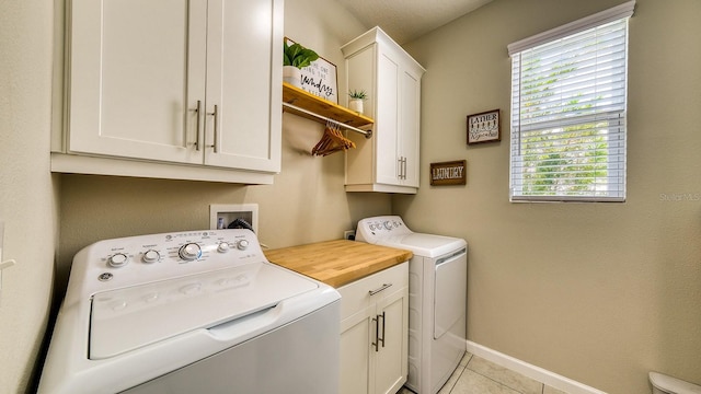 600 Buchannan Dr, Davenport, FL 33837 - laundry room with washing machine and clothes dryer, cabinet space, light tile patterned flooring, and baseboards