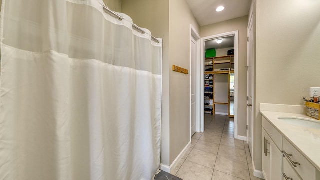 600 Buchannan Dr, Davenport, FL 33837 - full bath with tile patterned floors, vanity, baseboards, a shower with curtain, and a spacious closet