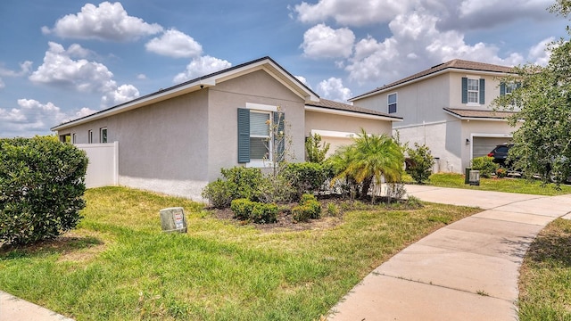 600 Buchannan Dr, Davenport, FL 33837 - view of side of home with driveway, stucco siding, a yard, and a garage